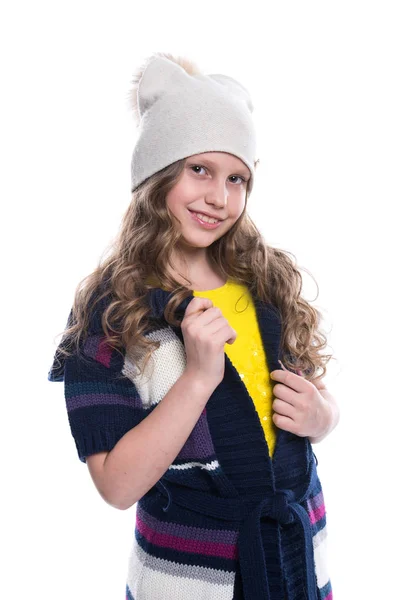 カラフルなセーター、シャツ、パンツ、白い背景で隔離の帽子を身に着けている巻き毛のヘアスタイルと、かわいいの笑顔の女の子。冬の服. — ストック写真