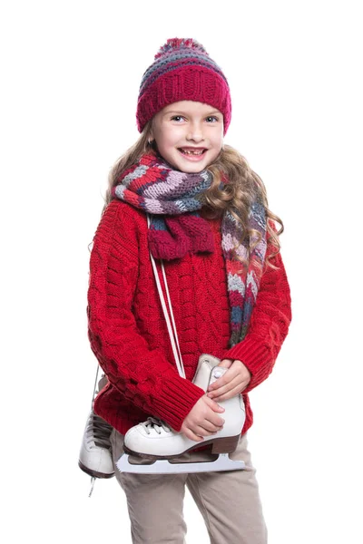 Menina sorridente bonito com penteado encaracolado vestindo camisola de malha, cachecol, chapéu e luvas com patins isolados no fundo branco. Roupas de inverno e conceito de esporte . — Fotografia de Stock
