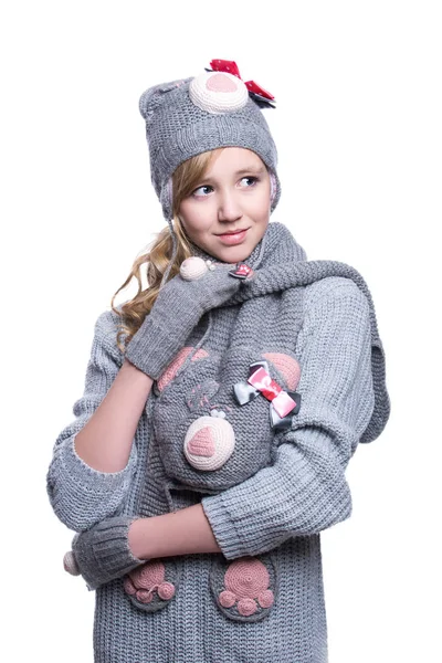 Linda menina adolescente alegre vestindo suéter difuso, cachecol, mitenes e chapéu isolado no fundo branco. Roupas de inverno . — Fotografia de Stock