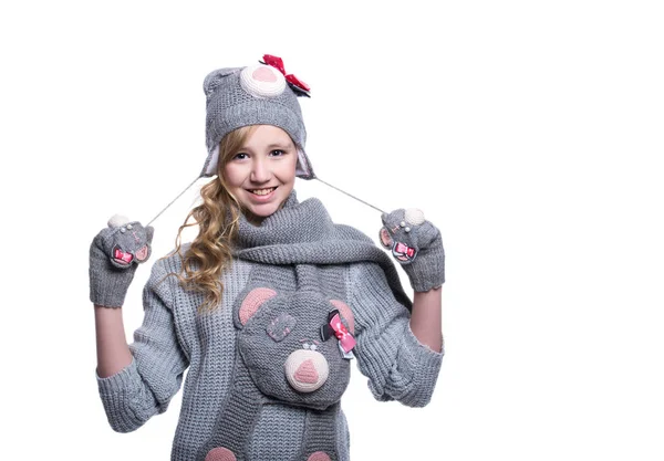 Linda menina adolescente alegre vestindo suéter difuso, cachecol, mitenes e chapéu isolado no fundo branco. Roupas de inverno . — Fotografia de Stock