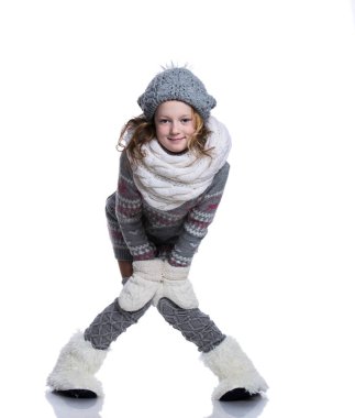 Beyaz arka plan üzerinde izole Studio poz mutlu güzel bir çocuk. Kış giysileri giyiyor. Örgü yün kazak, atkı, şapka, eldiven ve moda kışlık botlar ile kürk.