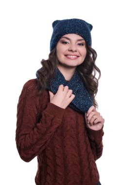 Örme kazak, atkı ve şapka giyen oldukça neşeli seksi genç kadın. Beyaz arka plan üzerinde izole. O gülümseyen ve duygular gösterilen. Kış giysileri.