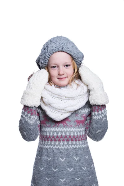 Beyaz arka plan üzerinde izole Studio poz mutlu güzel bir çocuk. Kış giysileri giyiyor. Örgü yün kazak, atkı, şapka ve eldiven.