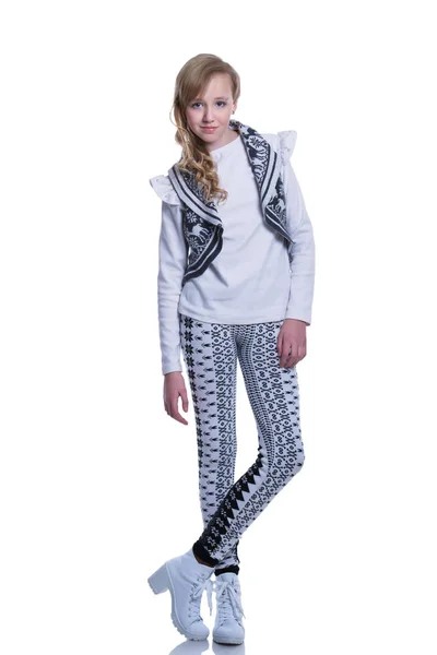 Doce menina adolescente alegre vestindo colete de malha, calças e botas modernas isoladas no fundo branco. Roupas de inverno . — Fotografia de Stock