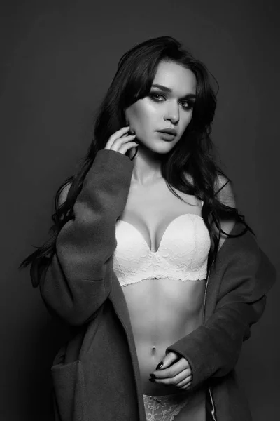 Photo en noir et blanc d'une fille brune séduisante en studio. Femme sexy en lingerie blanche. Image monochrome . — Photo