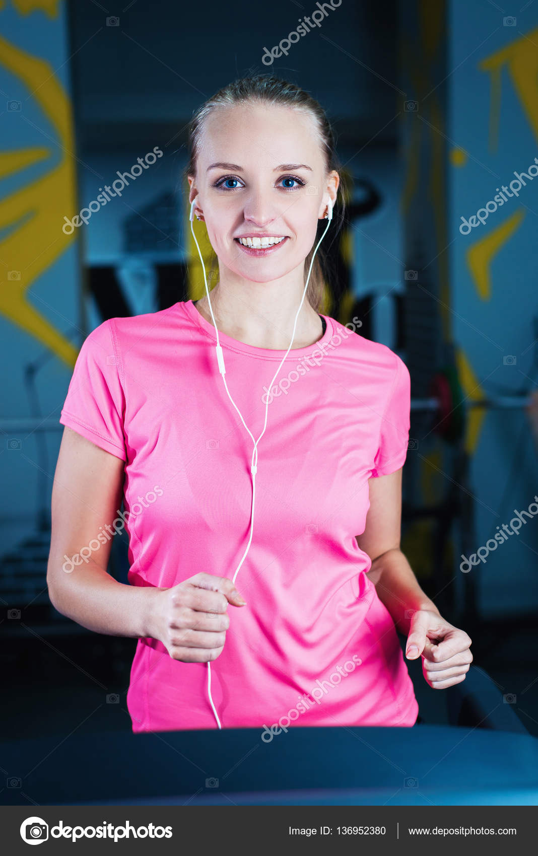 Attractive fitness girl running on machine treadmill. Pretty girl doing
