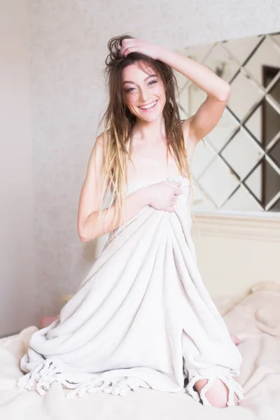 Portrait of sexy woman in bedroom. Happy smiling girl in bed covered with blanket. — Stock Photo, Image