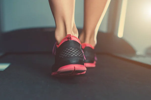 Spor salonunda treadmill çalışan spor ayakkabı kadın kas ayak.