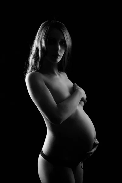 Monochrome portrait of happy pregnant woman with hands over tummy. Black and white photo. — Stock Photo, Image