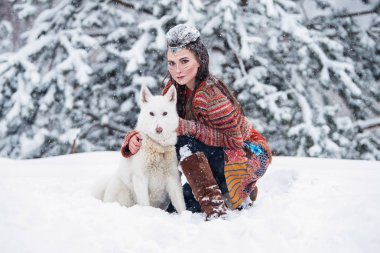 Geleneksel makyaj ve saç karlı kış ile yerli Kızılderili kadın. Bir eskimo köpek sarılma etnik elbiseli güzel kız.