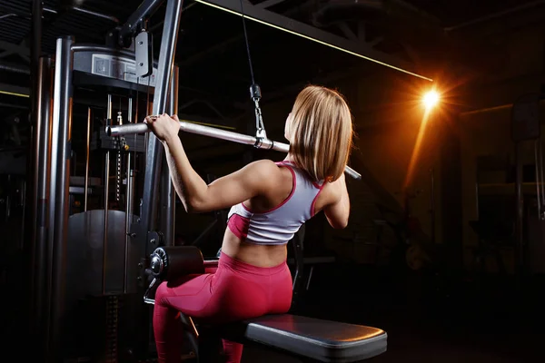 Joven mujer de fitness haciendo ejercicios de los principales grupos musculares en el gimnasio. Entrenamiento de fuerza . —  Fotos de Stock