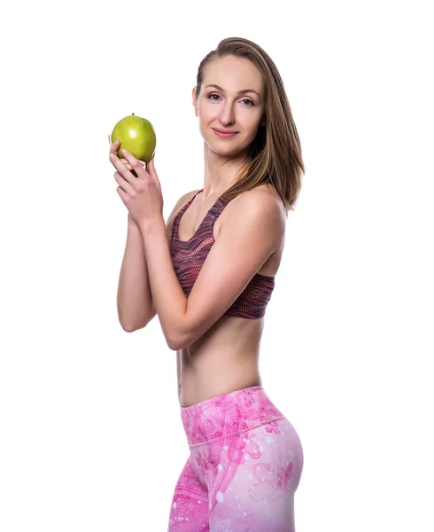 Happy sporty woman with green apple looking at camera in studio. Isolated on white background. — Stock Photo, Image
