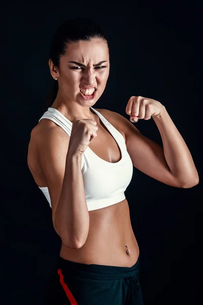 Boos fitness meisje klaar voor strijd op zwarte achtergrond. — Stockfoto