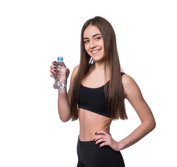 Modello di fitness femminile positivo dopo l'allenamento con una bottiglia di acqua pura su sfondo bianco . — Foto Stock