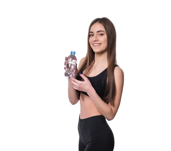 Modello di fitness femminile positivo dopo l'allenamento con una bottiglia di acqua pura su sfondo bianco . — Foto Stock