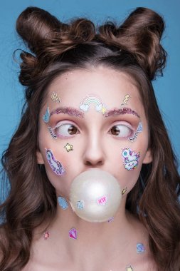 Yüzünde yapıştırılmış komik profesyonel makyaj ve emoji çıkartma ile kız güzel moda.