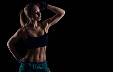 Kas siyah arka plan üzerinde gösterilen spor giyim sportif genç kız. Yanık tenli genç atletik kadın. Harika bir spor kadın bedeni.