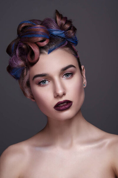 Beautiful girl with bright creative fashion makeup and colorful hairstyle. Studio portrait of beauty face