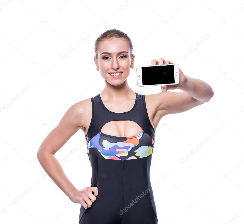 Happy fitness young woman wearing sportswear tracksuit showing blank smartphone screen isolated on white background.