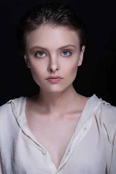 Dramatic portrait of a young seductive beautiful brunette girl with short haircut in the studio over black background. — Stock Photo, Image