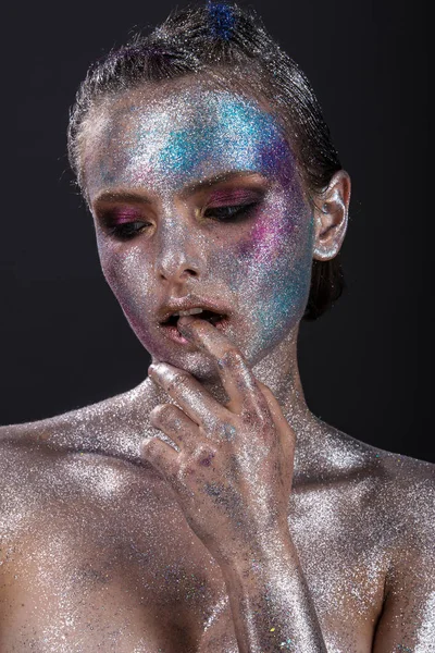 Modelo de moda con maquillaje brillante y brillo colorido y destellos en su cara y cuerpo . — Foto de Stock