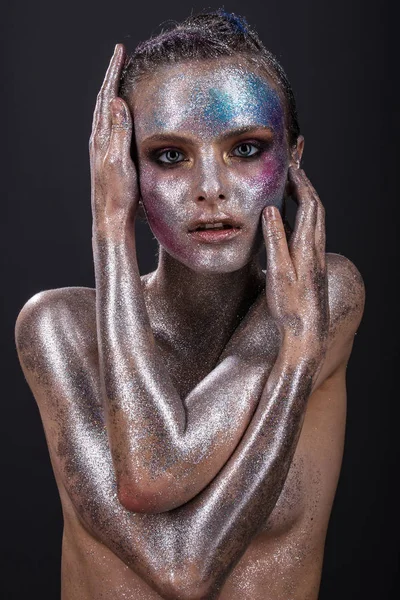 Modelo de moda con maquillaje brillante y brillo colorido y destellos en su cara y cuerpo . — Foto de Stock