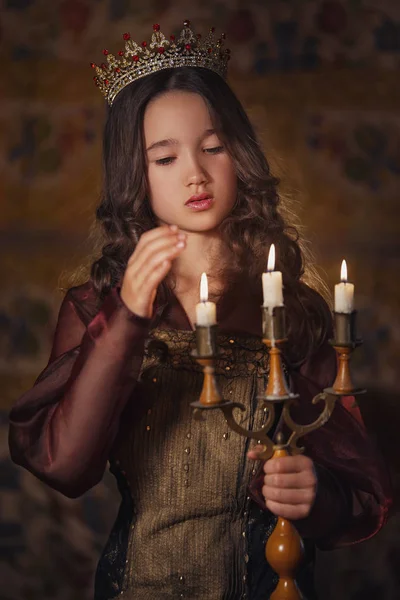 可爱的女孩戴皇冠用烛台的手的肖像。年轻的皇后或者公主. — 图库照片