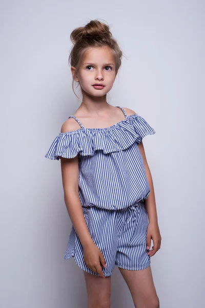 Magnifique petit mannequin sur fond blanc. Portrait de mignonne fille souriante posant en studio. — Photo