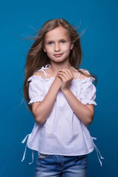 Piękna mała modelka na białym tle. Portret uroczej uśmiechniętej dziewczyny pozowanie w studio. — Zdjęcie stockowe