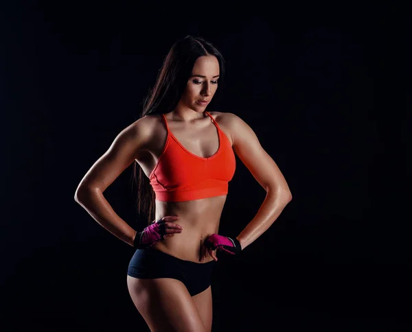 Niza mujer fitness sexy que muestra músculos abdominales aislados sobre fondo negro. Cuerpo femenino entrenado . — Foto de Stock