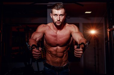 Kaslı vücut geliştirmeci yakışıklı erkekler çıplak gövde ile spor salonunda egzersiz yapıyor. Karın kasları ve pazı ile güçlü atletik bir adam.