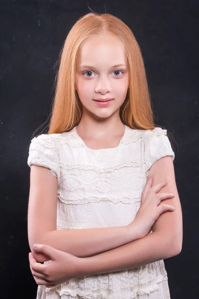Portret zbliżenie ładny mała dziewczynka z rude włosy w studio nad ciemnym tle. — Zdjęcie stockowe