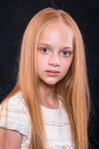 可爱的小女孩，红发头发在黑暗背景下的工作室的特写肖像. — 图库照片