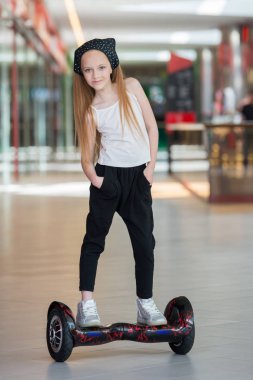 Alışveriş Merkezi Ticaret mini segway üzerinde mutlu ve gülümseyen Kız biniyor. Vurgulu kurulu veya gyroscooter üzerinde sürme genç.