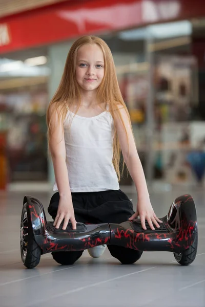 モールを取引でミニ セグウェイの幸せと笑顔の女の子。ホバー ボードまたは gyroscooter に乗ってティーンエイ ジャー. — ストック写真