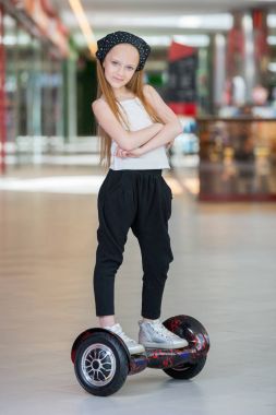Alışveriş Merkezi Ticaret mini segway üzerinde mutlu ve gülümseyen Kız biniyor. Vurgulu kurulu veya gyroscooter üzerinde sürme genç.