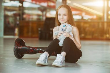 Mini segway ve Peluş ayı bebek t ile mutlu ve gülümseyen kız