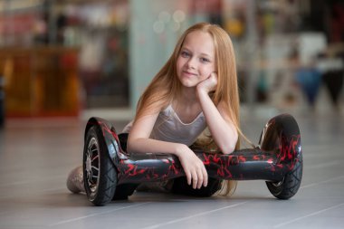 Alışveriş Merkezi Ticaret mini segway mutlu ve gülümseyen kız. Vurgulu kurulu veya gyroscooter üzerinde sürme genç.