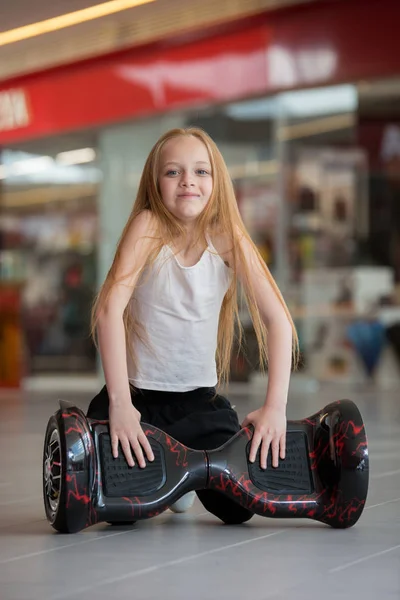 Alışveriş Merkezi Ticaret mini segway mutlu ve gülümseyen kız. Vurgulu kurulu veya gyroscooter üzerinde sürme genç.