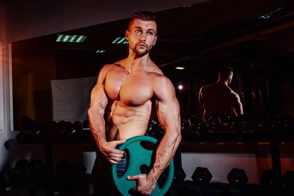 Musculosos hombres atléticos fuertes bombeando los músculos y el entrenamiento en el gimnasio. Guapo culturista chico haciendo ejercicios con barra . — Foto de Stock