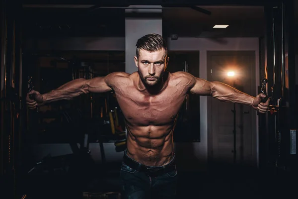 Musculoso culturista hombres guapos haciendo ejercicios en el gimnasio con el torso desnudo. Tipo atlético fuerte con músculos abdominales y bíceps . — Foto de Stock