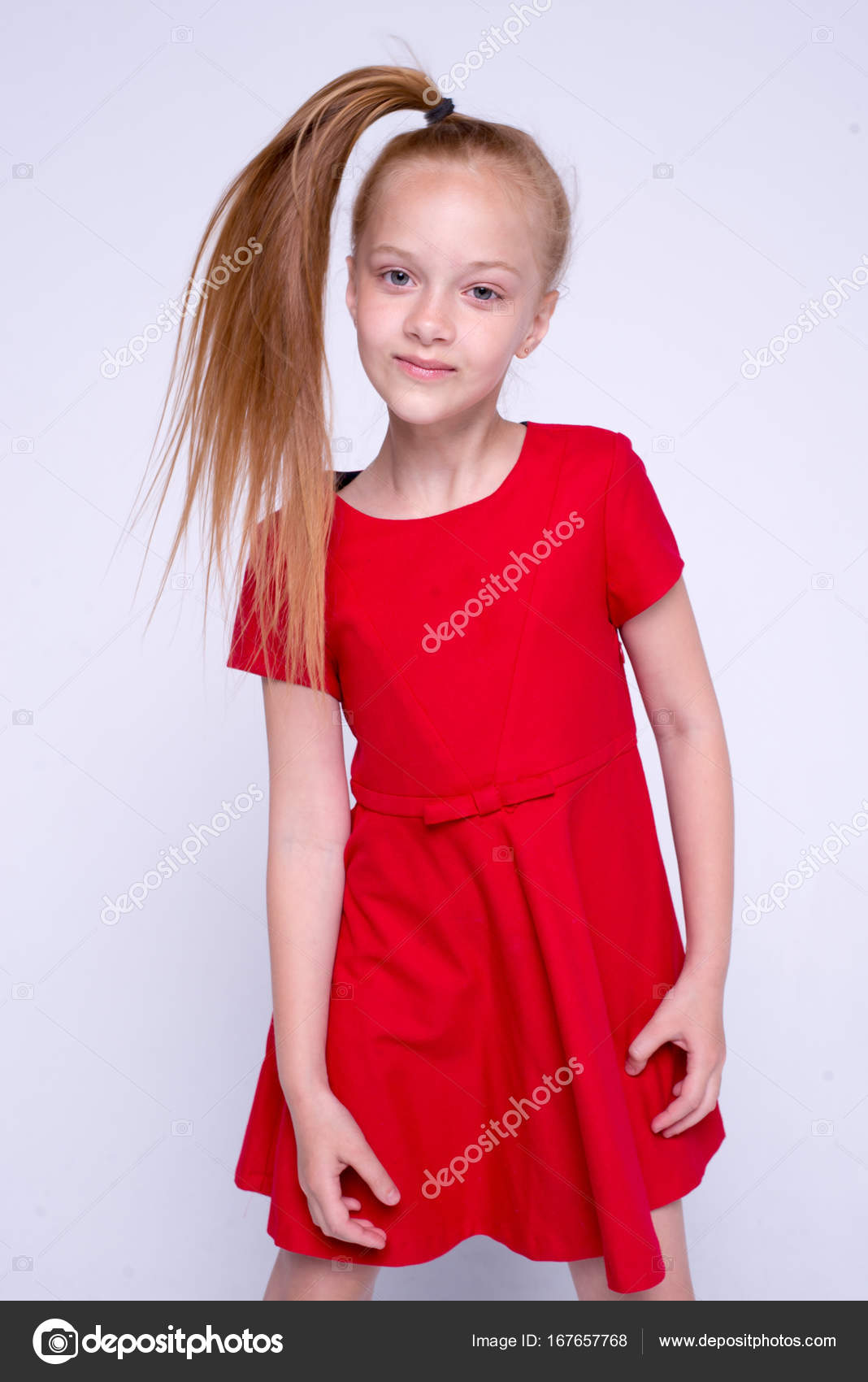 Beautiful Little Redhead Girl In Red Dress Posing Like Model On White