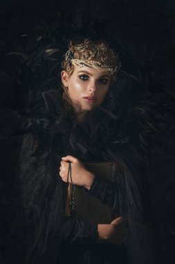 Karanlık Gotik arka plan üzerinde siyah fantezi kostüm karanlıkta kraliçesi. Yüksek moda güzellik modeli koyu makyaj ile.