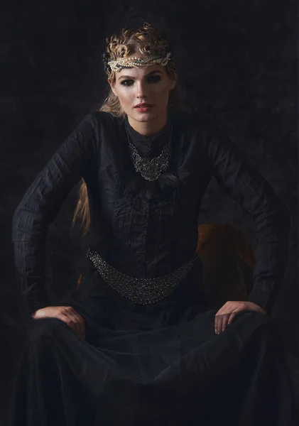 Koningin van de duisternis in zwarte fantasy kostuum op donkere gotische achtergrond. High fashion schoonheid model met donkere make-up. — Stockfoto