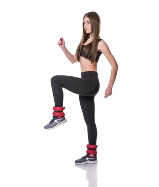 Beyaz arka plan üzerinde izole fitness salonunda aerobik egzersiz yaparak atletik genç kadın.