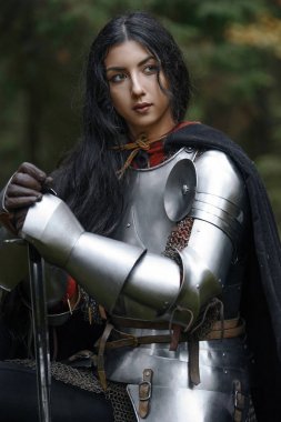 Gizemli bir ormanda CHAINMAIL ve zırh giyen bir kılıç ile bir güzel savaşçı kız.