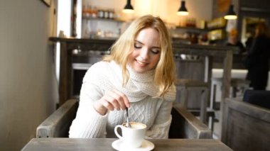 Genç güzel kadın cafede gülümseyen ve kahve kokusu zevk.