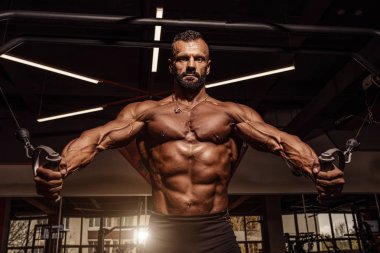 Yakışıklı adam büyük kas spor salonunda çalışma dışarı ile. Kaslı vücut egzersizleri yapıyor.