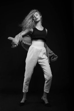 Genç kadın siyah arka plan üzerinde poz tam uzunlukta tek renkli portresi. Moda studio vurdu.