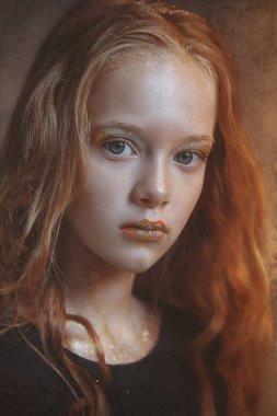 Dramatik bir genç Kızıl saçlı kız parlak makyaj ve renkli parlak ve pırıltılar yüzünde portresi.